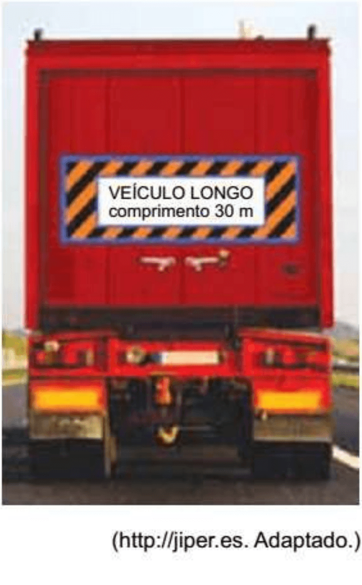 Fotografia da traseira de um caminhão com placa Veículo longo, comprimento 30 m, e crédito adaptado.