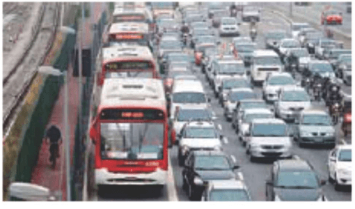 Fotografia de corredor viário congestionado em São Paulo, com ônibus e automóveis.